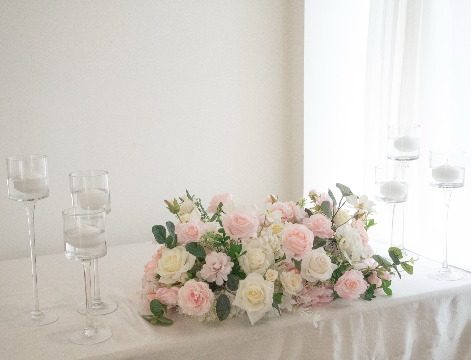 A low floral arrangement along the front of a head table.