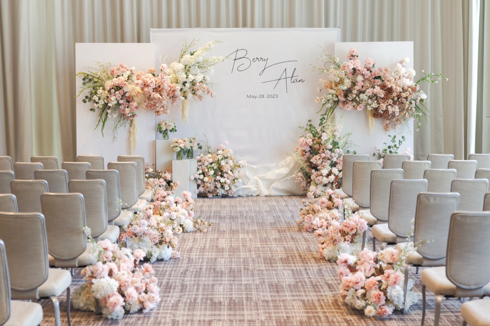 Ceremony chairs and a flower-lined aisle before guests arrive.